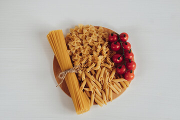 Different Types of Pasta and Cherry Tomatoes on the Tray on the White Background Table