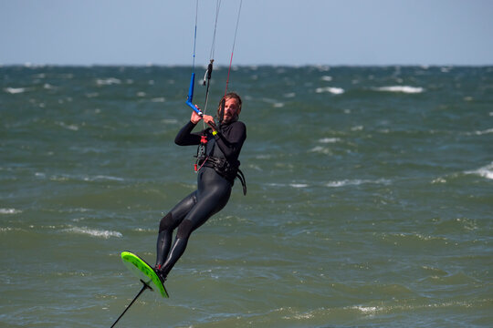 Male Kite Foil Surfer with beard and long hair on the sea