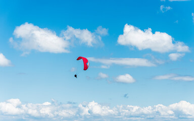 A tandem paraglider flight against a beautiful blue sky. Top view of the embers in the Beskid Mały. A popular place in Silesia. Bielsko Biała, Poland