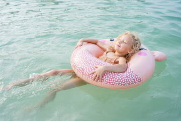 Girl with inflatable ring floating on sea