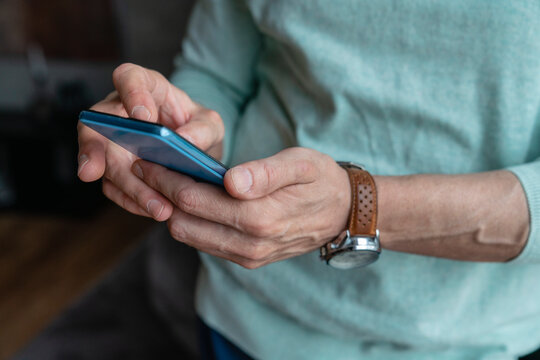 Hands of man using smart phone at home