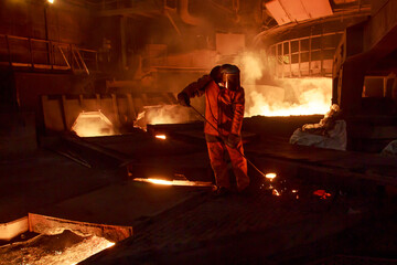 Man works in blast furnace workshop.