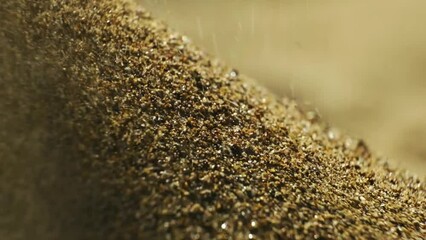 small grains of sand fall from above. close up shot of falling sand particles.slow motion.4K. GOLDEN SAND