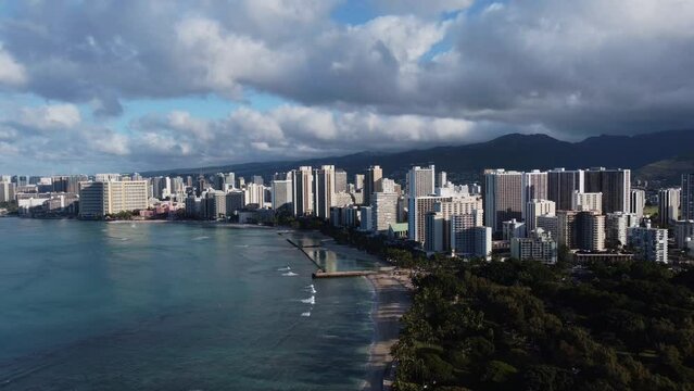 4K cinematic crane drone shot of the entirety of Waikiki, including the beach and hotels, on the island of Oahu. This stunning Hawaiian cityscape was filmed just after sunrise using a DJI Mini 2.