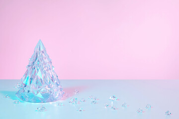 Abstract surreal Winter scene with Christmas decorations made of crystal glass. Xmas tree and icicles on holographic pink background with copy space, front view.