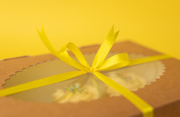 Craft gift present box with cupcakes on yellow background. Birthday present, March 8, Mother's Day, Valentine's Day