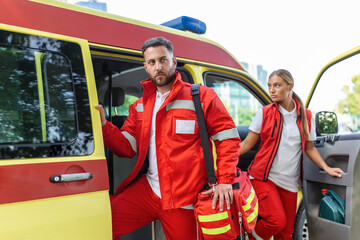 Fototapeta na wymiar Paramedic nurse and emergency doctor at ambulance with kit. a paramedic, standing at the rear of an ambulance, by the open doors.