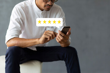 Customer pressing on mobile phone with five stars icon for feedback review satisfaction service	