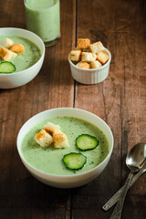 Cucumber Gazpacho. Green fresh cold soup with cucumber slice and croutons on a wooden table. healthy vegan food