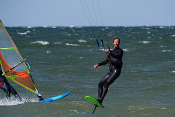 Male kite foil surfer and wind surfer on the sea. Close Up