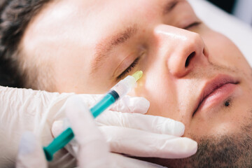 Injectable tissue stimulator on man face in beauty salon