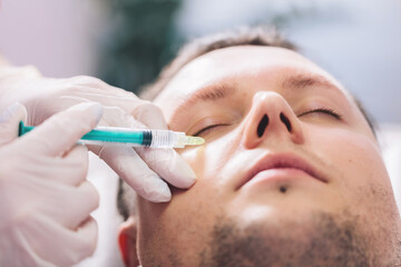 Injectable tissue stimulator on man face in beauty salon