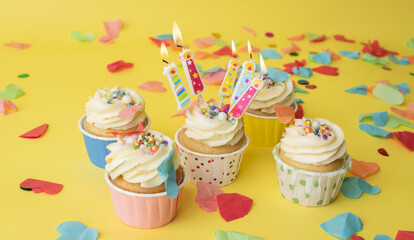 A colorful birthday cupcake with a colored candle