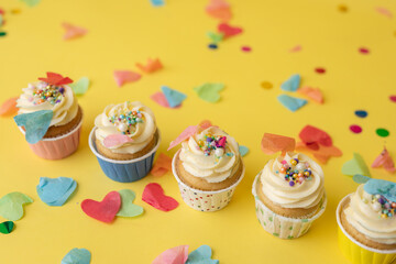 Birthday cupcakes in colorful colors on yellow background