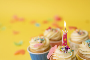 Birthday cupcakes in colorful colors on yellow background