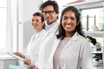 Fototapeta premium science, work and people concept - international group of happy scientists in laboratory