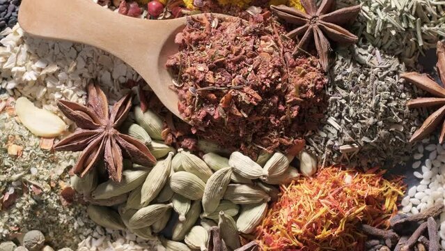 4K. Spices. Aromatic Indian spices on a slate background. Spices and herbs rotate on a stone background. Assortment of Seasonings, condiments, Dry colorful condiments. Culinary, cooking ingredients