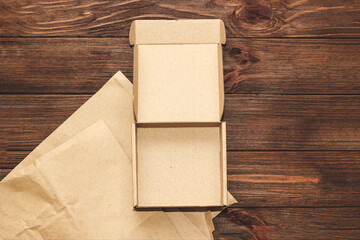 Kraft paper with eco box for packing goods on a wooden background.