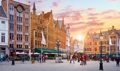 Poster België. Brugge. Marktplaats. Historisch centrum van de oude stad. Middeleeuwse architectuur van het marktplein van Brugge en straatlantaarns tijdens de avondzonsondergang. © Yasonya