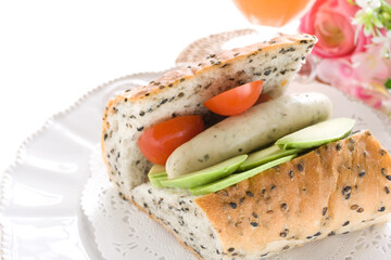 Homemade pork sausage and avocado with cherry tomato French bread sandwich