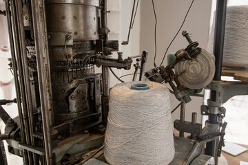 vintage circular knitting machine with a skein of white thread