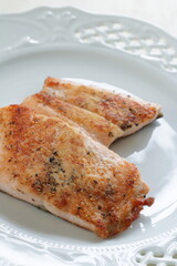 Homemade pan fried Salmon fillet on white plate 