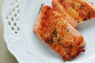 Homemade pan fried Salmon fillet on white plate 