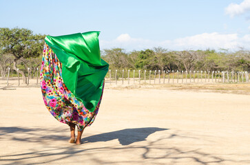 Woman dancing typical Wayuu dance. Indigenous culture of La Guajira, Colombia. Desert landscape.