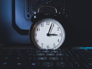Background photo of alarm clock with computer keyboard, means times is money, or times to work