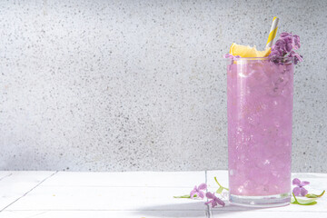 Lilac drink. Alternative organic natural cocktail or mocktail, infused drink from lilac flowers. Lilac lemonade with ice in a tall long glass. - obrazy, fototapety, plakaty