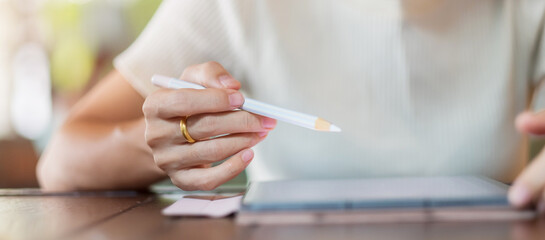 woman using tablet for sms messages, hand holding pencil typing touchscreen mobile phone in cafe or modern office. lifestyle, technology, Social media and network concept