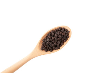 Black chickpeas in wooden spoon on white background, close-up. Design element, copy space