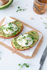 Beautiful breakfast with avocado and poached egg. Pea microgreens. Gray background with breakfast