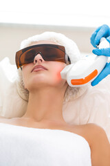 Anti-Aging Skin Procedures. Female Receiving Facial Beauty Treatment While Removing Pigmentation in Clinic During Pulsed Laser Light Therapy or IPL Rejuvenation