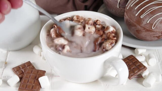 Homemade hot chocolate bomb with marshmallow and chocolates and nuts, Cooking making cocoa with chocolate ball, dropping coca bomb in milk
