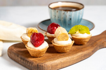 Fruit tartlet. Strawberry, kiwi and banana tartlet on a white background. close up