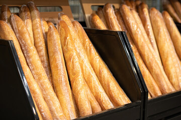 Horizontal shot of fresh warm baguettes set out in modern grocery store, copy space