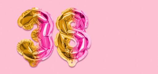 Rainbow foil balloon number, digit thirty eight on a pink background. Birthday greeting card with inscription 38. Top view. Numerical digit. Celebration event, template. Banner