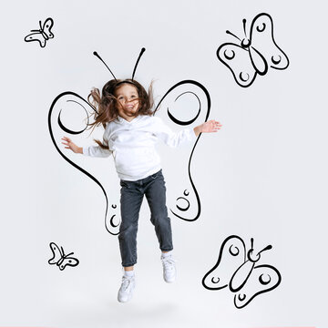 Creative portrait of cute kid, little girl flying like butterfly isolated on grey background with pencil sketch. Concept of ideas, imagination, international children's day
