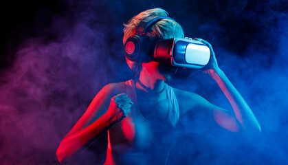 Obraz premium Blonde Hair Woman plays VR games with Goggles, have fun. Virtual reality is future gaming connect