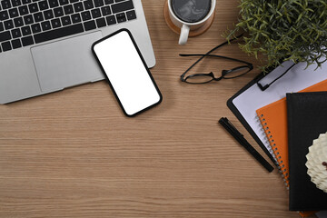 Simple workplace with laptop computer, mobile phone, glasses and coffee cup. Top view