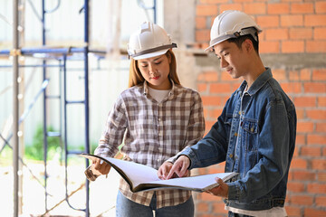 Young engineers supervising progress of construction project together. Industry, Engineer, construction concept