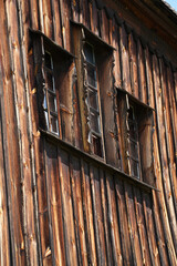 windows in a house sheathed with wooden boards