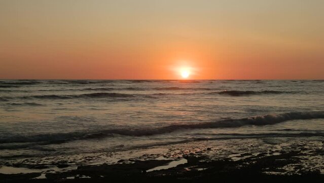 the sun just above the horizon during sunset from playa sirena beach at corcovado national park of costa rica