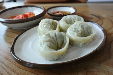 Dumplings are served on a round plate.