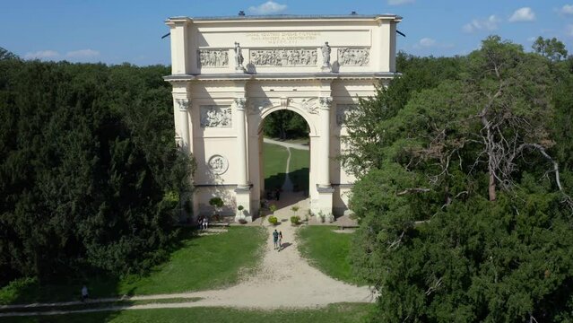 Couple standing below triumphal arch of Diana's temple, Valtice, drone.