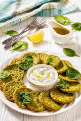 spinach pancakes on white plate with sauce