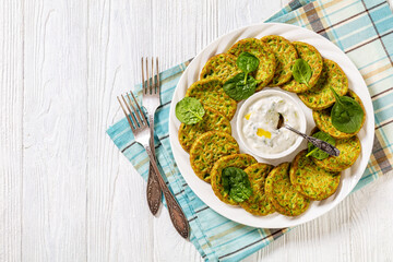 spinach pancakes on white plate with sauce