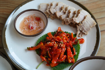 It is a Korean dish of thinly sliced boiled pork wrapped in spicy radish and pickled cabbage. It is sometimes eaten with salted shrimp and wrapped in kimchi.