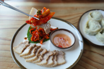 It is a Korean dish of thinly sliced boiled pork wrapped in spicy radish and pickled cabbage. It is sometimes eaten with salted shrimp and wrapped in kimchi.
